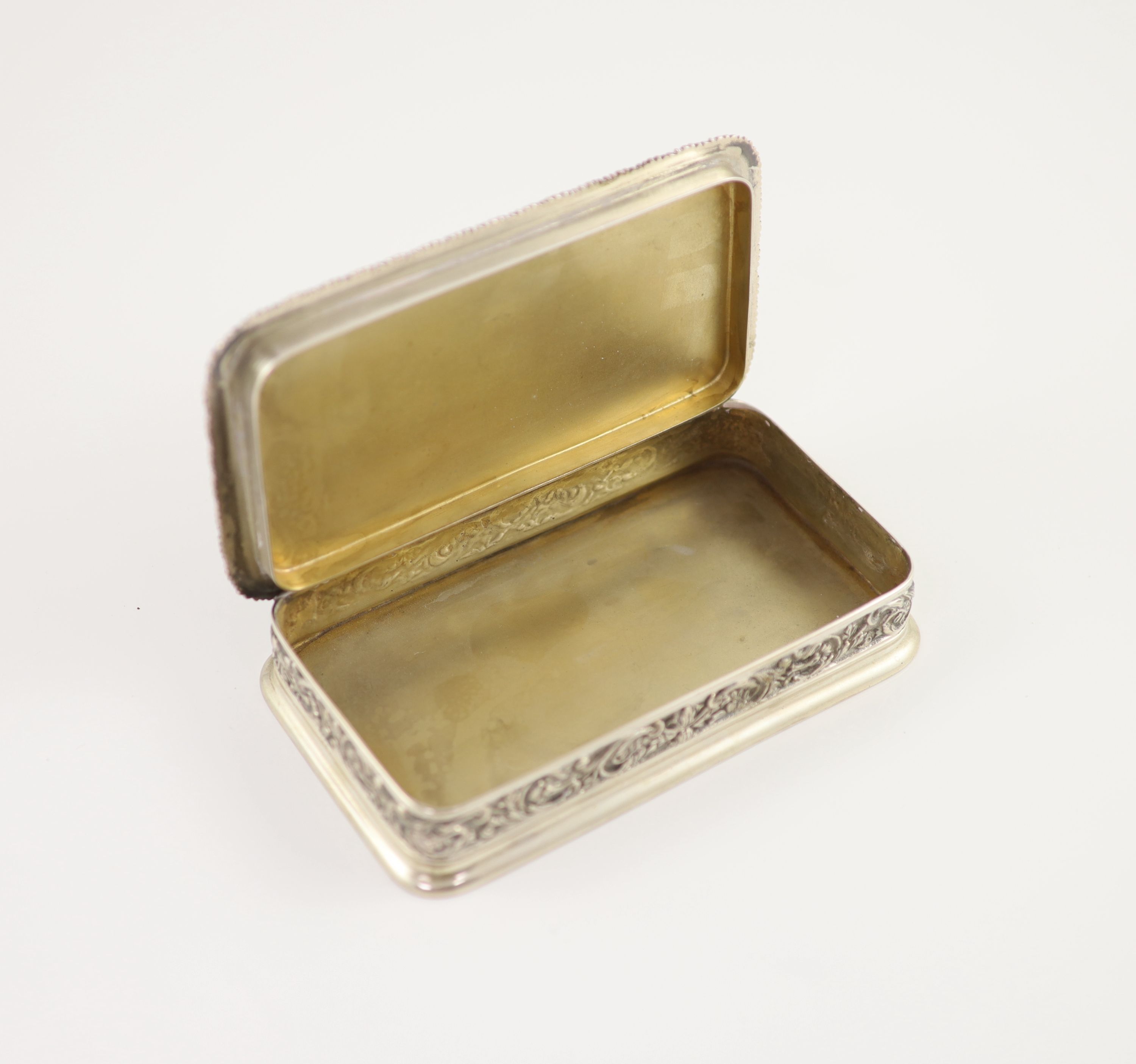 A 20th century Portuguese 833 standard silver rectangular box and cover, the lid cast and chased in high relief with travellers approaching a town,